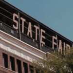 A dramatic view of a State Fair sign on a brick building, captured outdoors during the day.