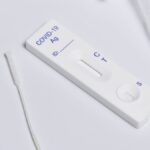 Close-up of a COVID-19 rapid antigen test kit showing the testing strip and swab.