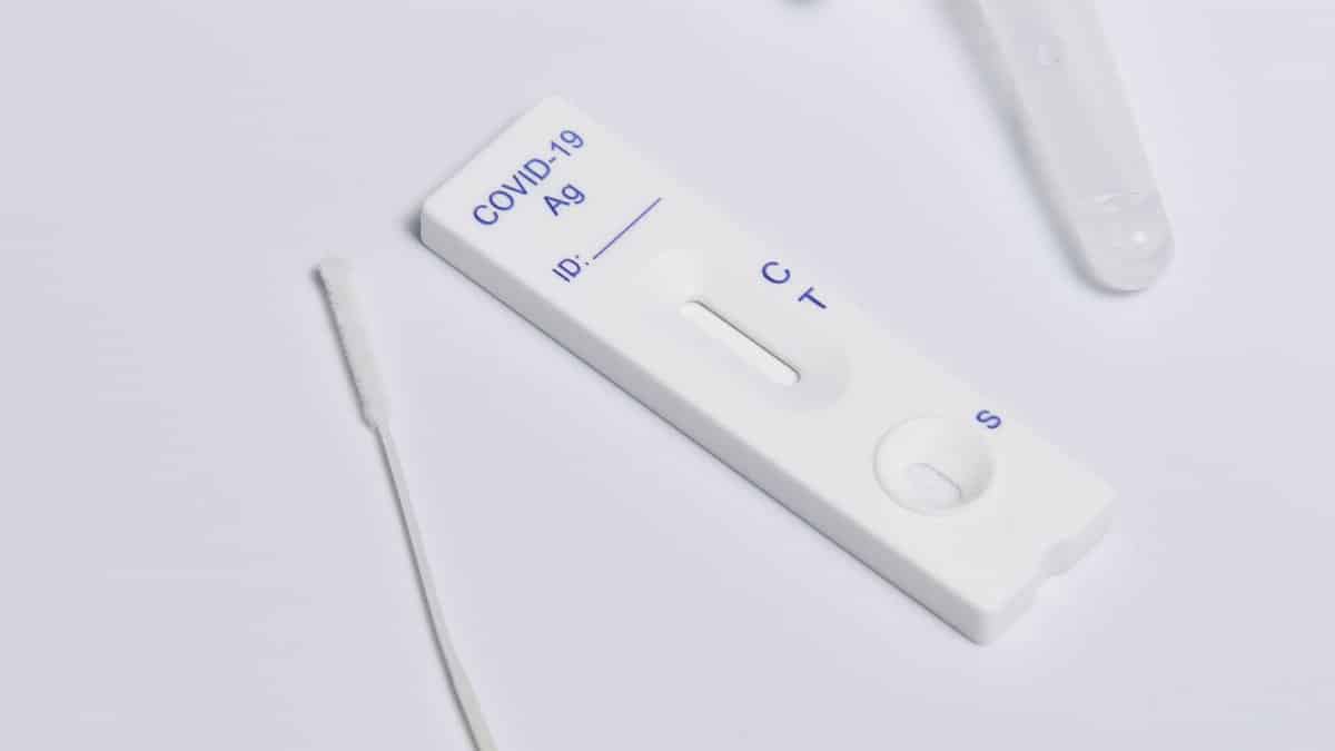 Close-up of a COVID-19 rapid antigen test kit showing the testing strip and swab.
