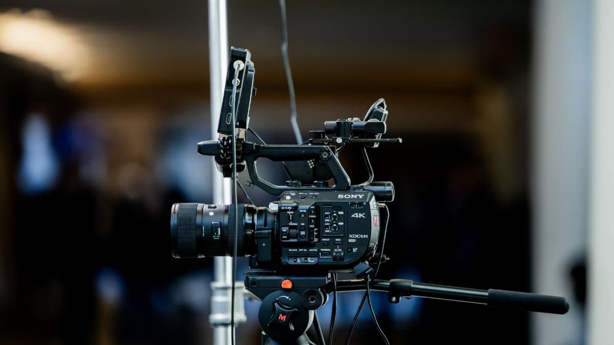 High-quality 4K video camera setup on a tripod indoors, perfect for event filming.