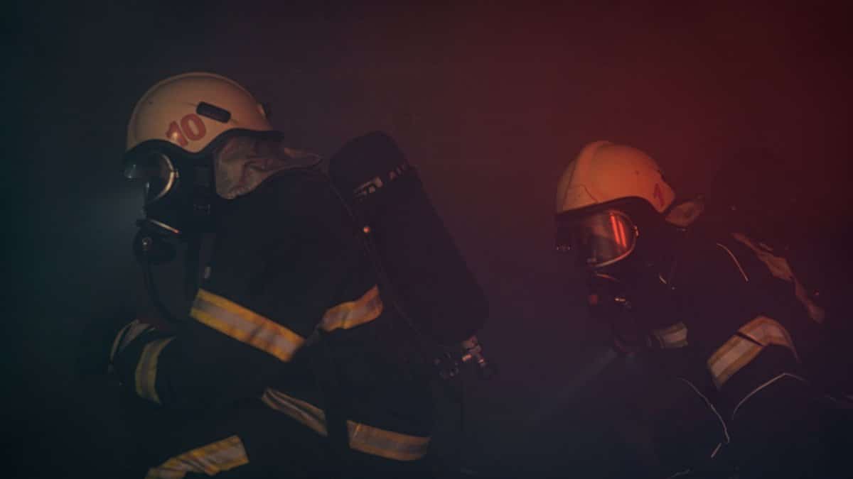 Brave firefighters wearing helmets and gear in a smoky environment, ensuring safety and rescue.