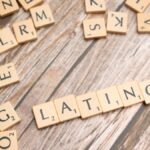 Wooden Scrabble tiles spelling 'Latino' on a textured wooden surface, emphasizing cultural identity.