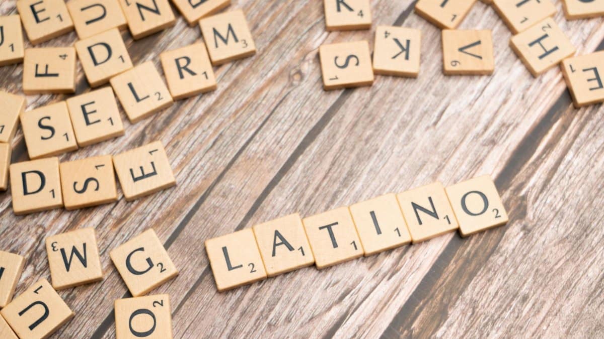 Wooden Scrabble tiles spelling 'Latino' on a textured wooden surface, emphasizing cultural identity.