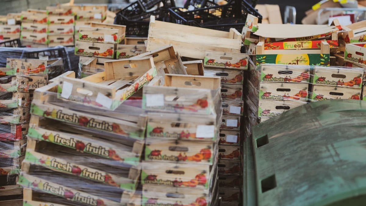 Piles of wooden fruit boxes in an outdoor market area, ideal for food or recycling themes.