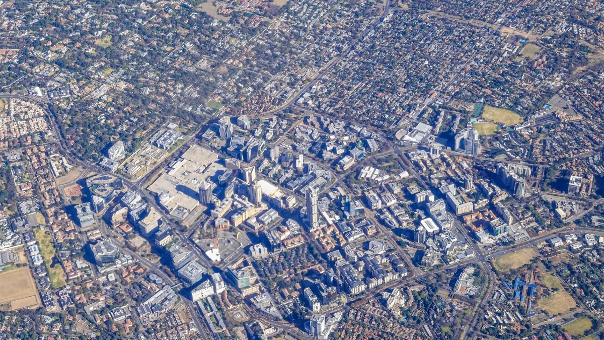 Explore a vast urban landscape from above with distinctive city architecture and sprawling neighborhoods.