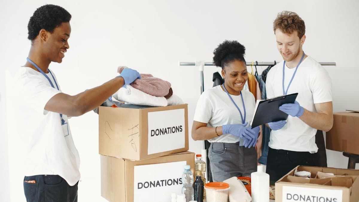 Dedicated volunteers sorting donation boxes indoors for community support.
