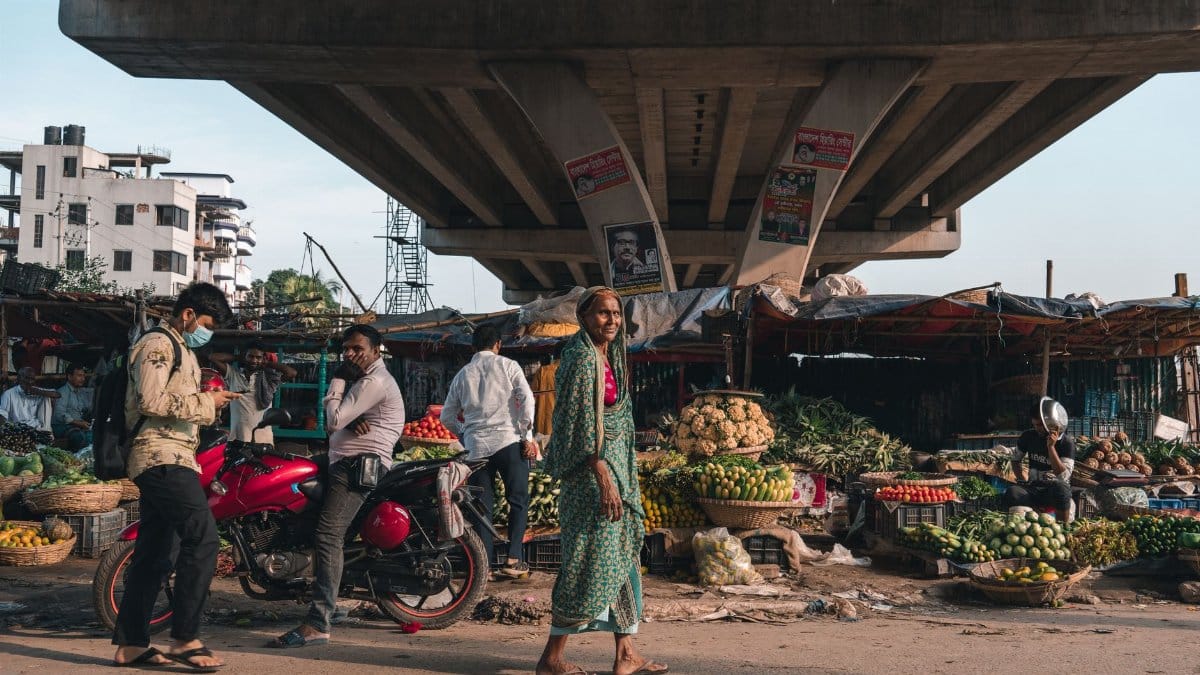 A bustling urban market set beneath an overpass, capturing daily life and commerce.