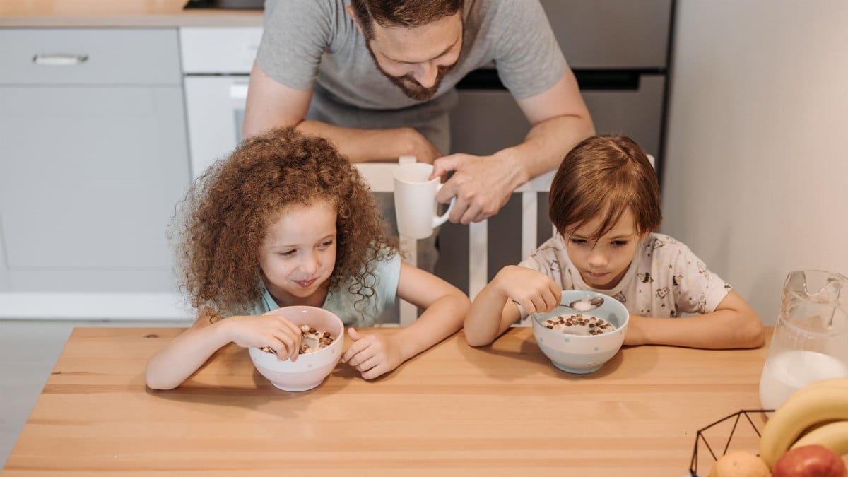 Father and children enjoying a hearty breakfast at home, creating a warm family moment.