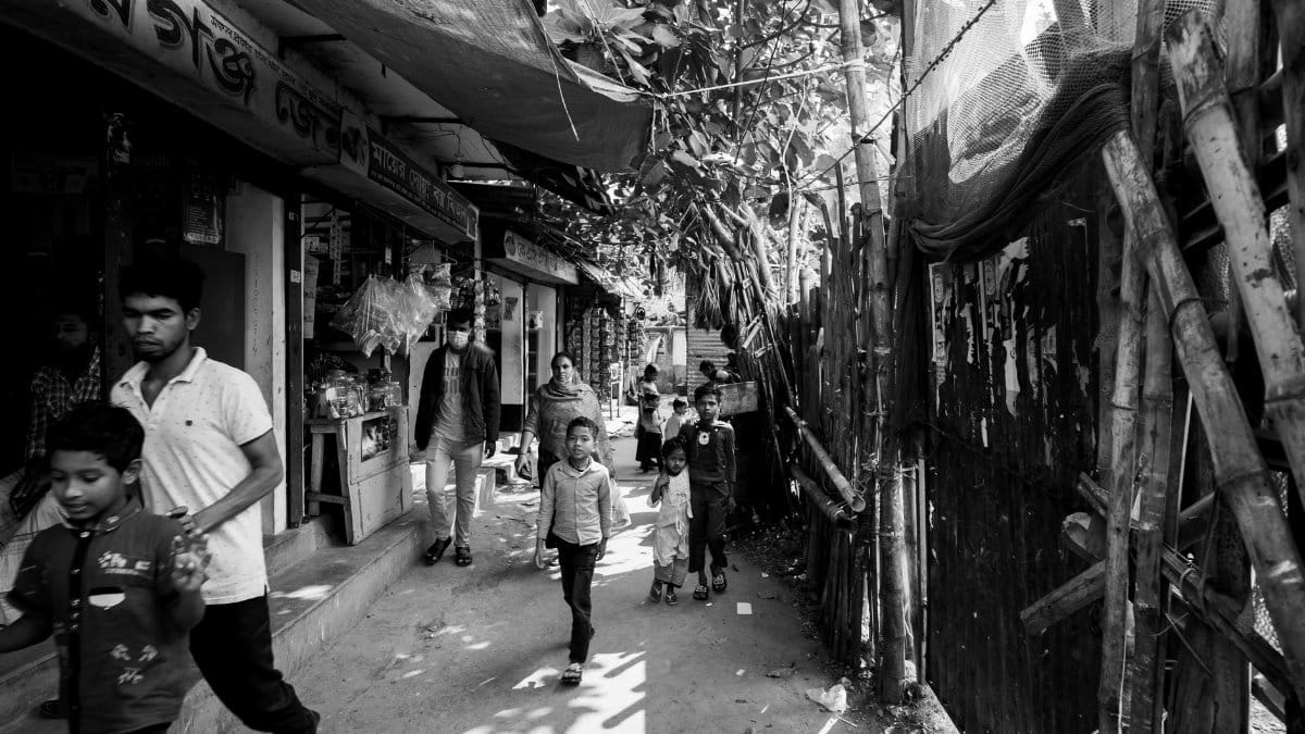 Black and white street scene in Dhaka, Bangladesh, featuring local residents and typical urban environment.