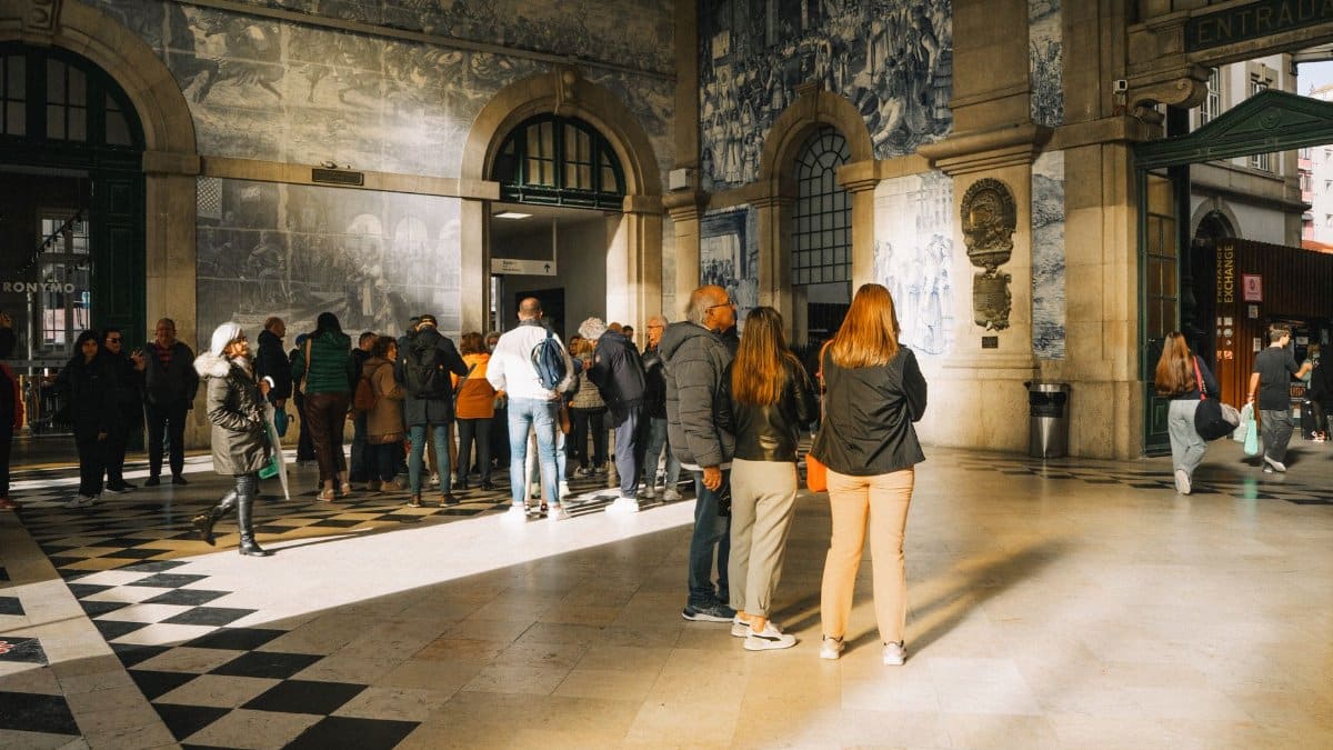 Visitors exploring the iconic São Bento Station showcasing beautiful azulejos in Porto, Portugal.