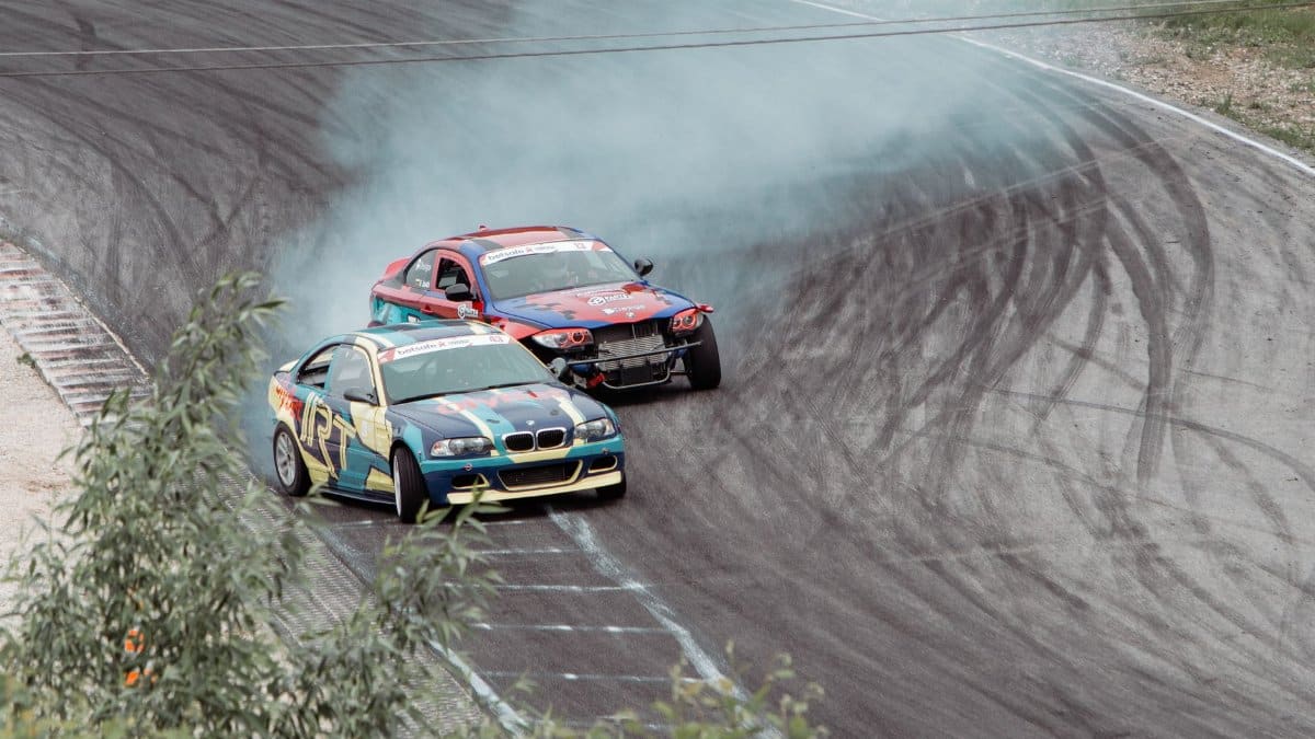 Action-packed drift race capturing colorful cars on a smoky track in Lithuania.