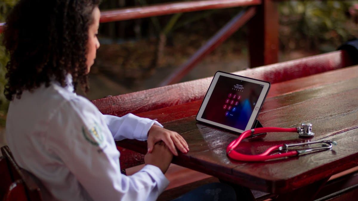 Female healthcare worker uses a tablet with stethoscope outdoors in São Paulo, Brazil.