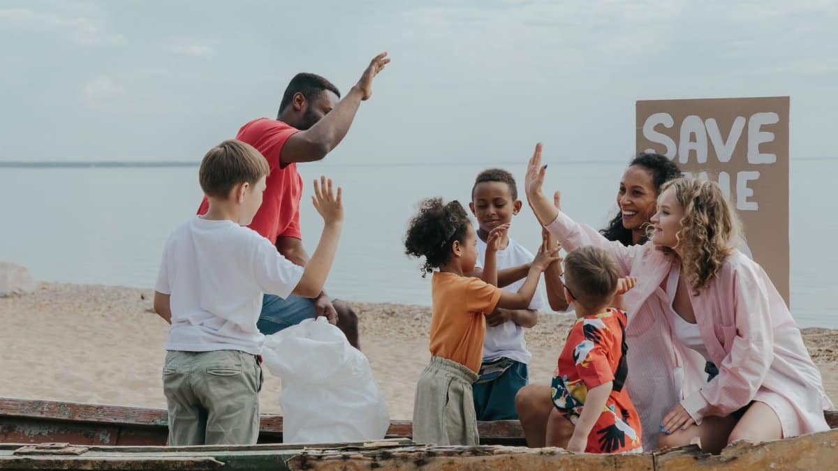 A diverse group of people enjoying a beach cleanup, promoting 'Save the Planet'.