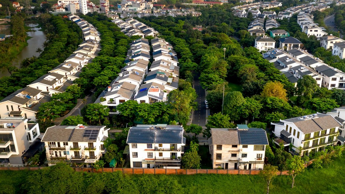 A stunning aerial view showcasing green trees and housing in a peaceful residential area.