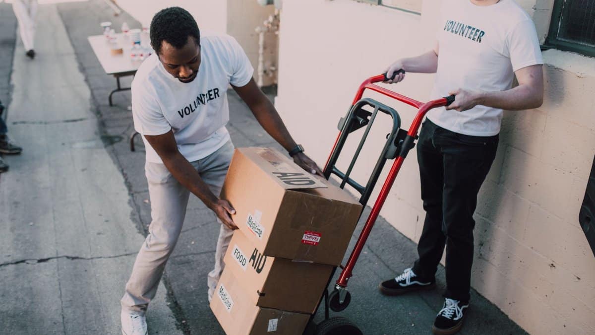 Volunteers move aid boxes for a charity event, emphasizing community support and social impact.