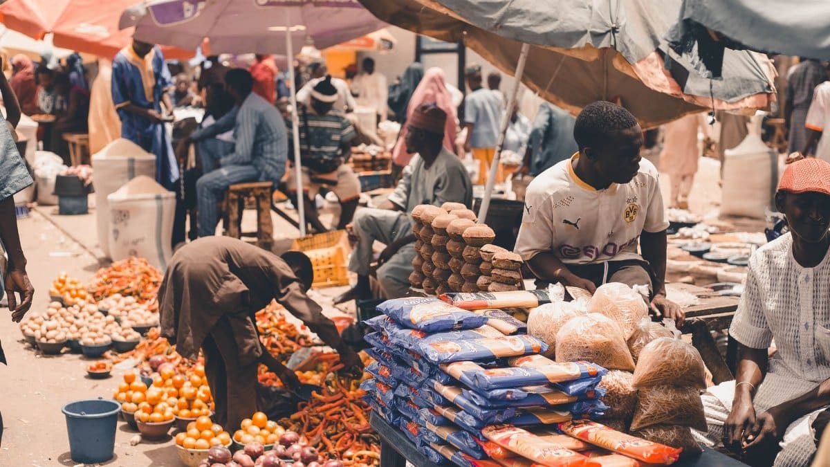 Lively market scene showcasing fresh produce and vendors under colorful umbrellas, capturing the essence of local trade.