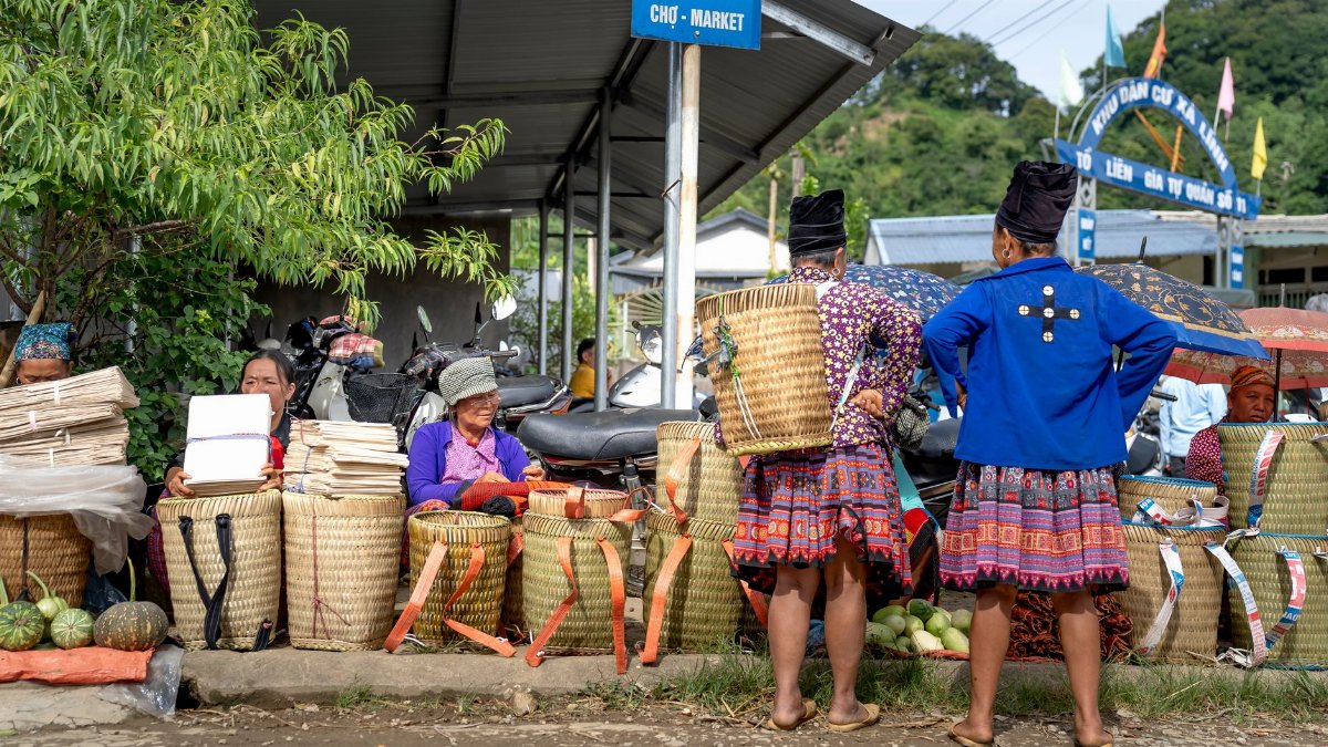 Vibrant local market with women selling handmade woven baskets and fresh produce.