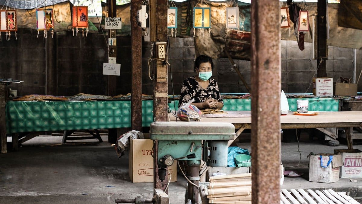 Elderly Asian woman with face mask in a market setting during pandemic.