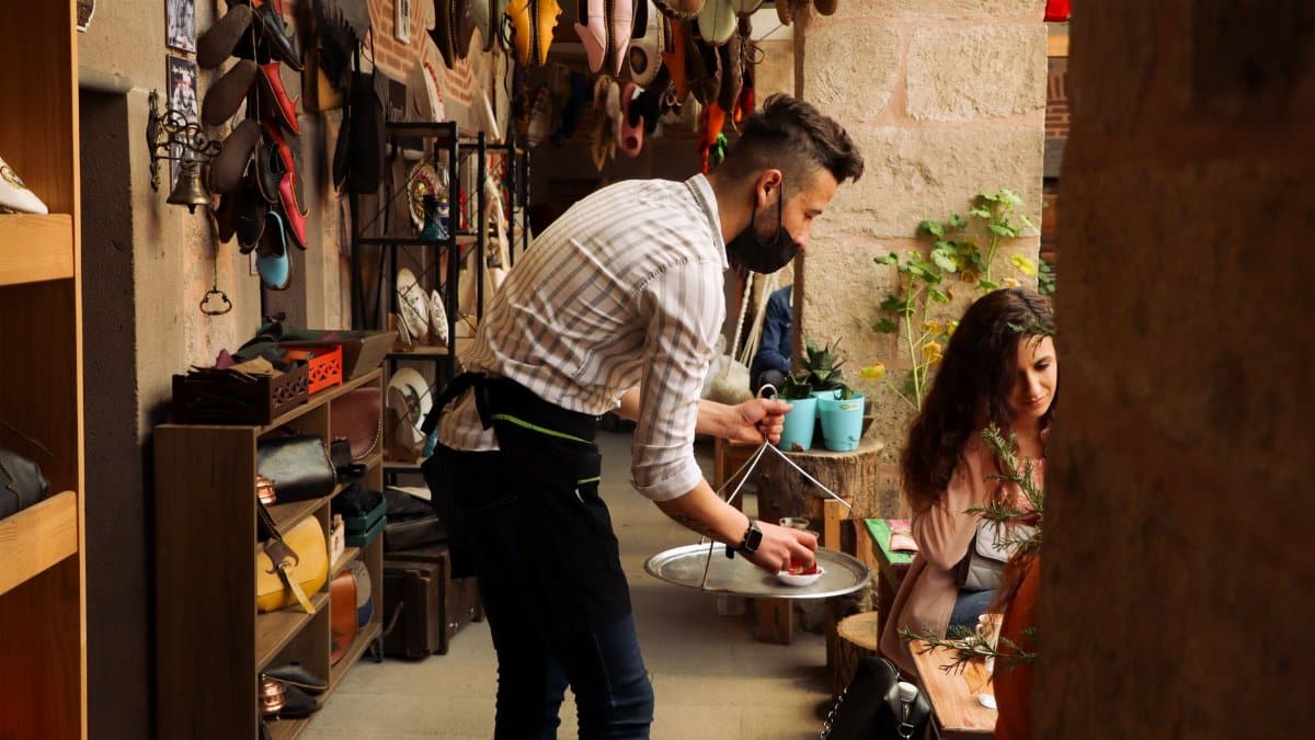 A waiter in a stylish cafe in Afyonkarahisar serves drinks. Modern Turkish dining experience.