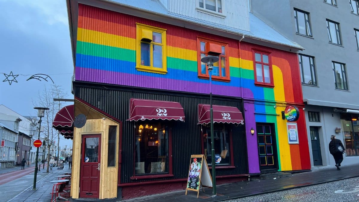Vibrant building with rainbow facade on a Reykjavik street displaying LGBTQ+ pride.
