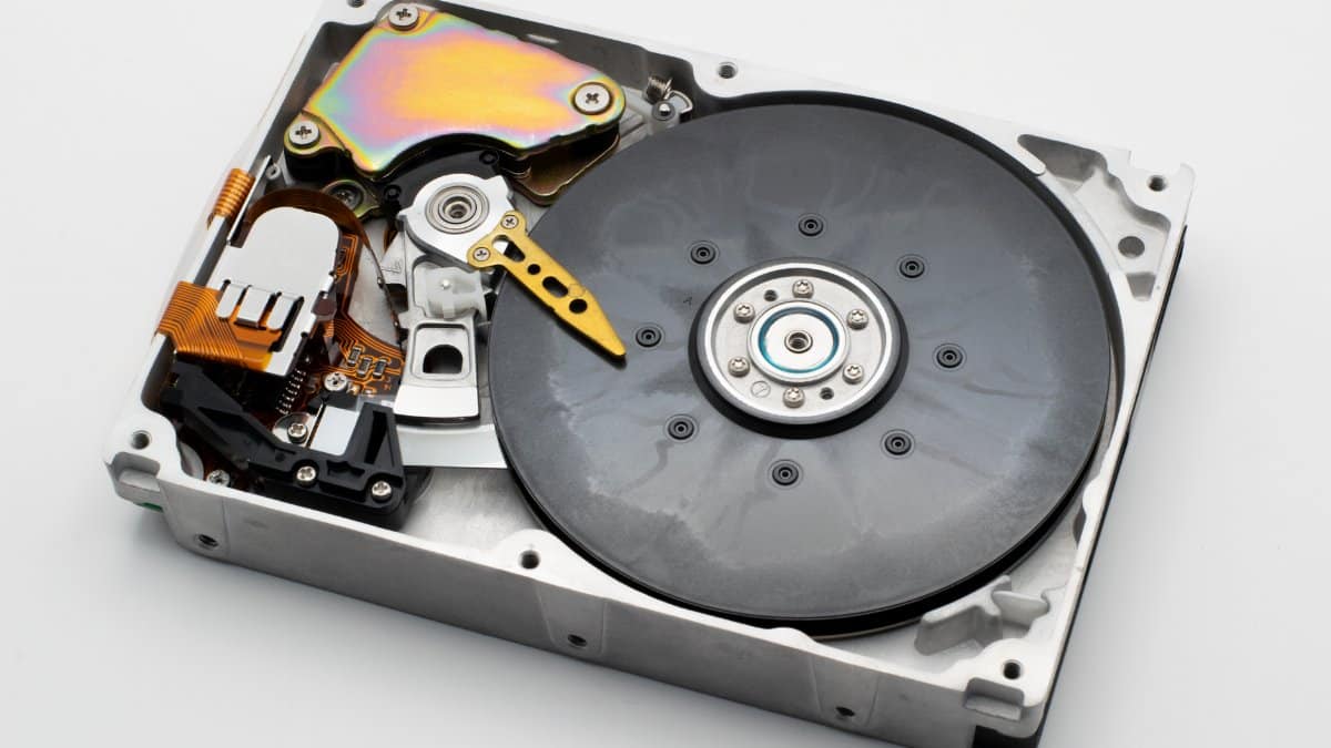 Internal view of a hard disk drive revealing its disk platter and read/write head for data storage.