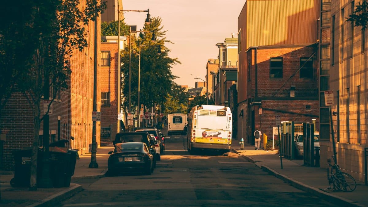 Vibrant city street view with a bus and cars under warm sunset lighting in Boston.
