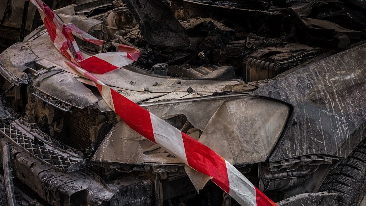 Close-up of a wrecked car covered with safety tape in Kyiv, Ukraine.