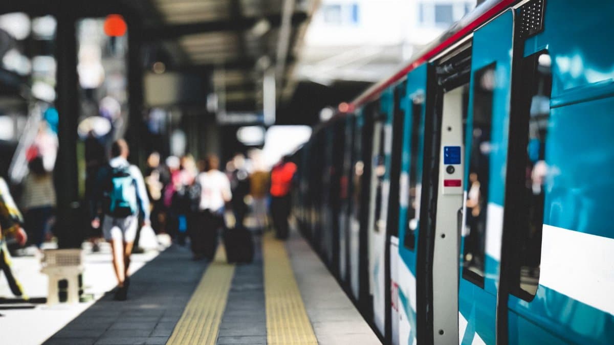 Commuters at an Istanbul train station platform during summer, capturing urban life and public transportation.