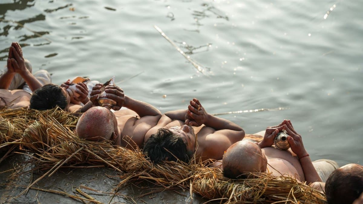 Devotees perform sacred rituals by the riverbank, symbolizing spiritual devotion.
