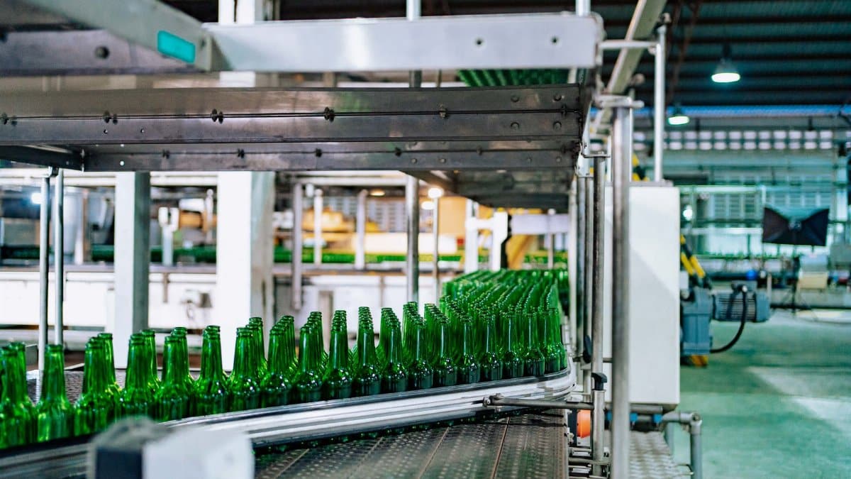 Streamlined glass bottle manufacturing process in factory setting, showcasing assembly line automation.