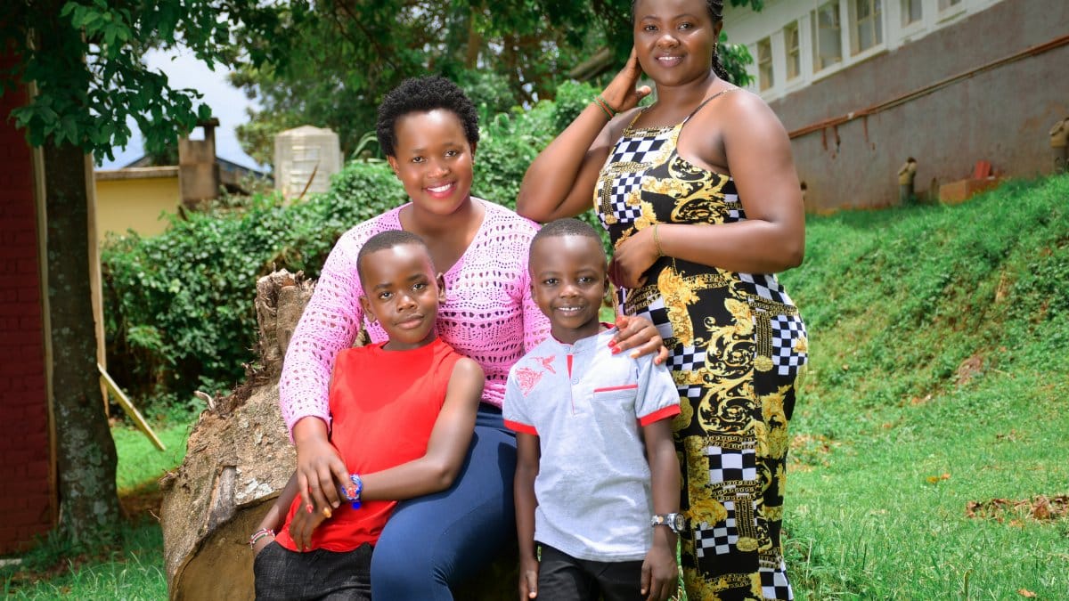 Smiling family of four enjoying a sunny day outdoors, celebrating happiness and togetherness.