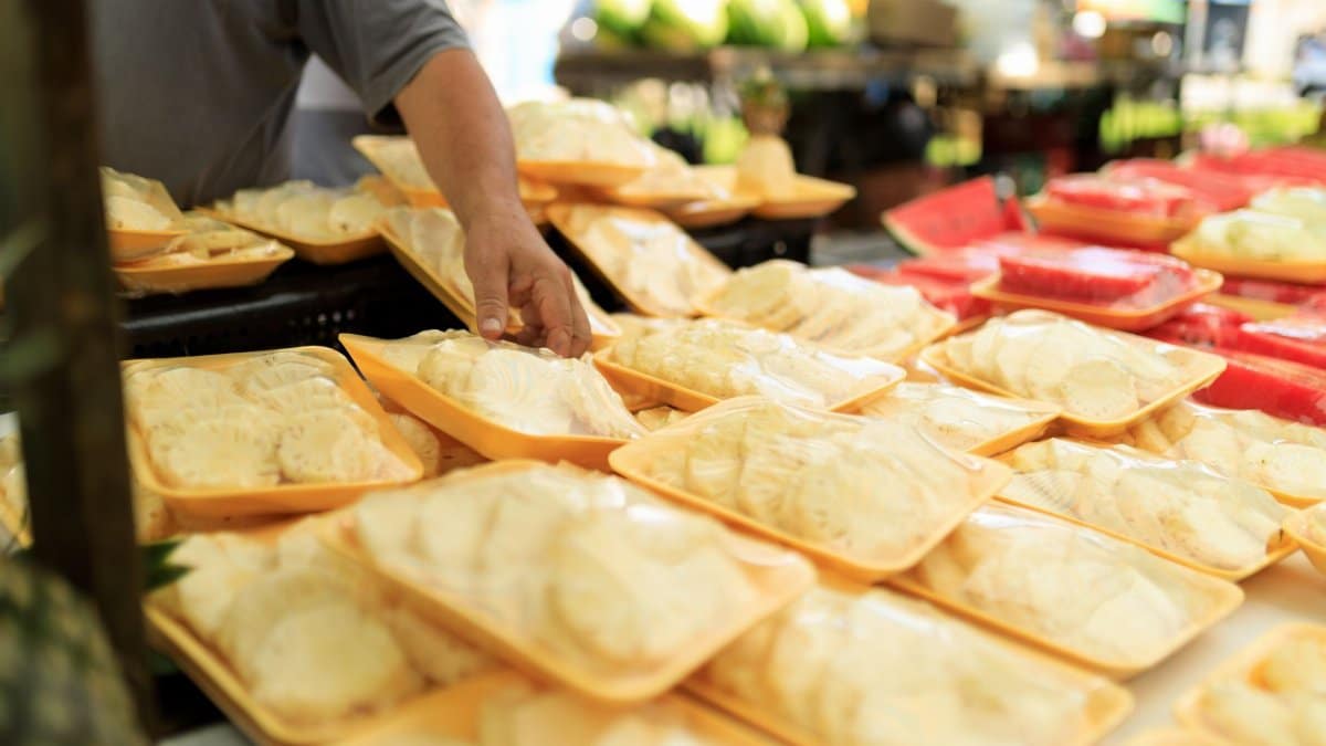 A person picking fresh packaged food at an outdoor market.