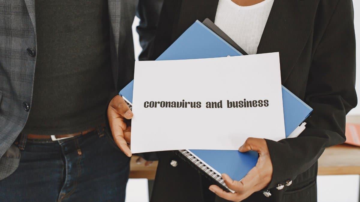 Business professionals hold a document about coronavirus impact with formal attire visible.
