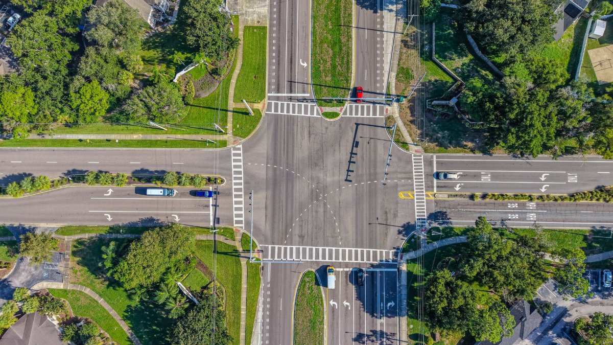 High-resolution aerial view of a traffic intersection in Florida featuring multiple vehicles and lush greenery.