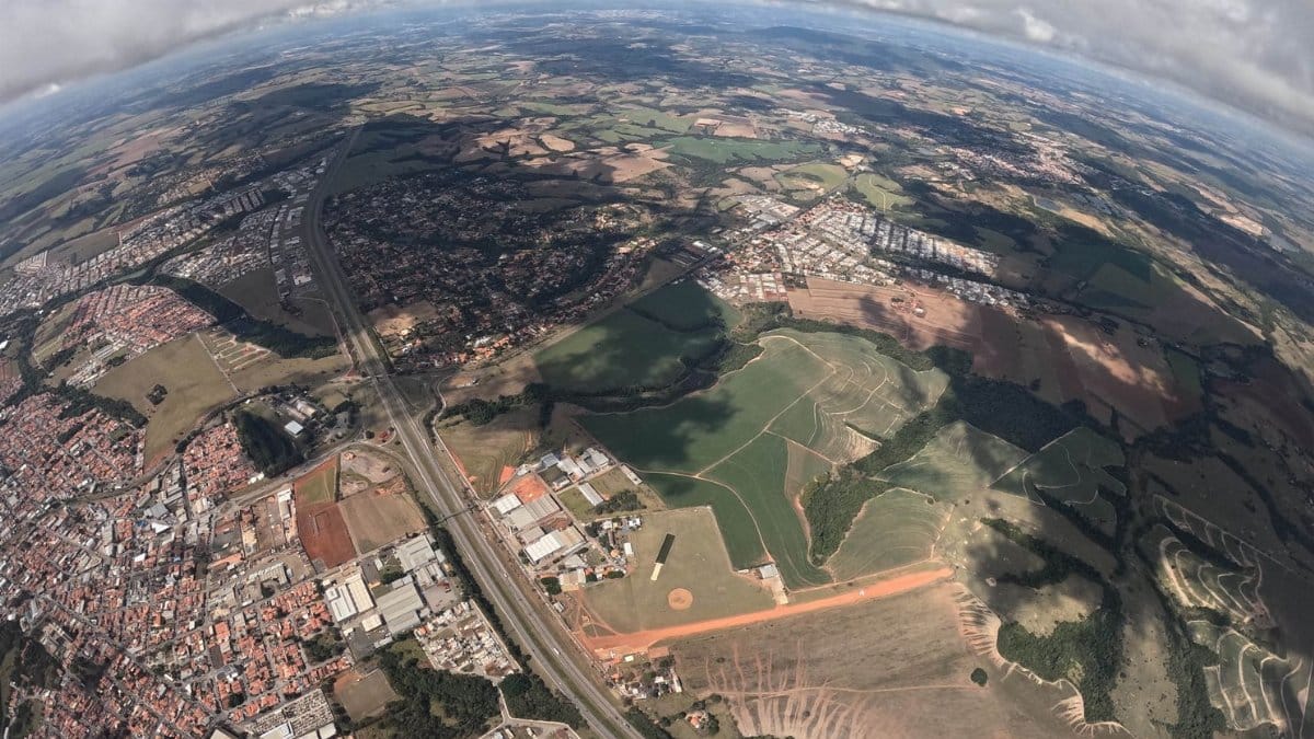 Gorgeous aerial view showcasing urban and rural landscapes with fields and clouds.