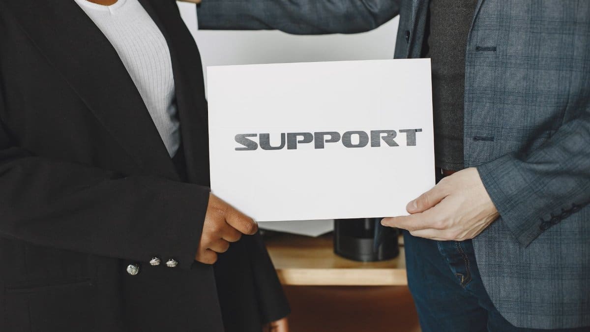 Business diversity and support concept with professionals holding a support sign.