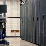 Contemporary computer on support between telecommunication racks and cabinets in modern data center