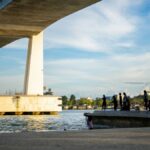 Children swimming and playing under the Marcelo Fernan Bridge at sunset in Mandaue, Philippines.