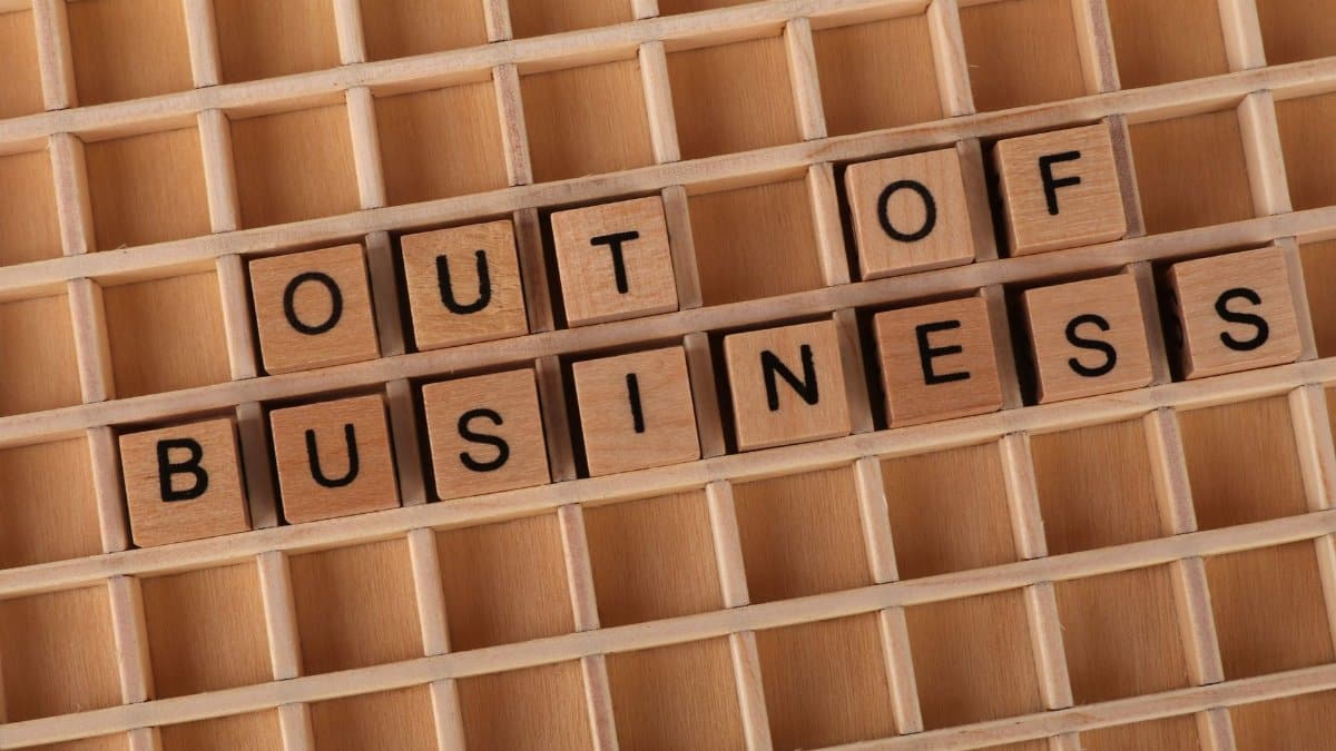 Wooden blocks spelling 'Out of Business', conveying closure or financial difficulties.