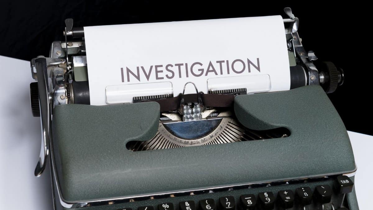 A classic typewriter with the word 'INVESTIGATION' typed on paper, symbolizing mystery and retro style.