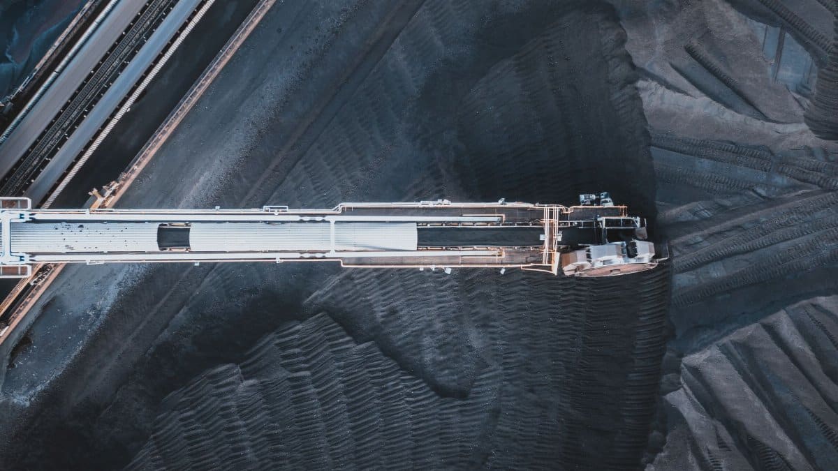 Top view of black coal moving on modern conveyor belts in industrial area in daytime