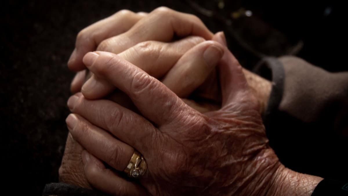 Close-up of aged and youthful hands intertwined, symbolizing connection and care.