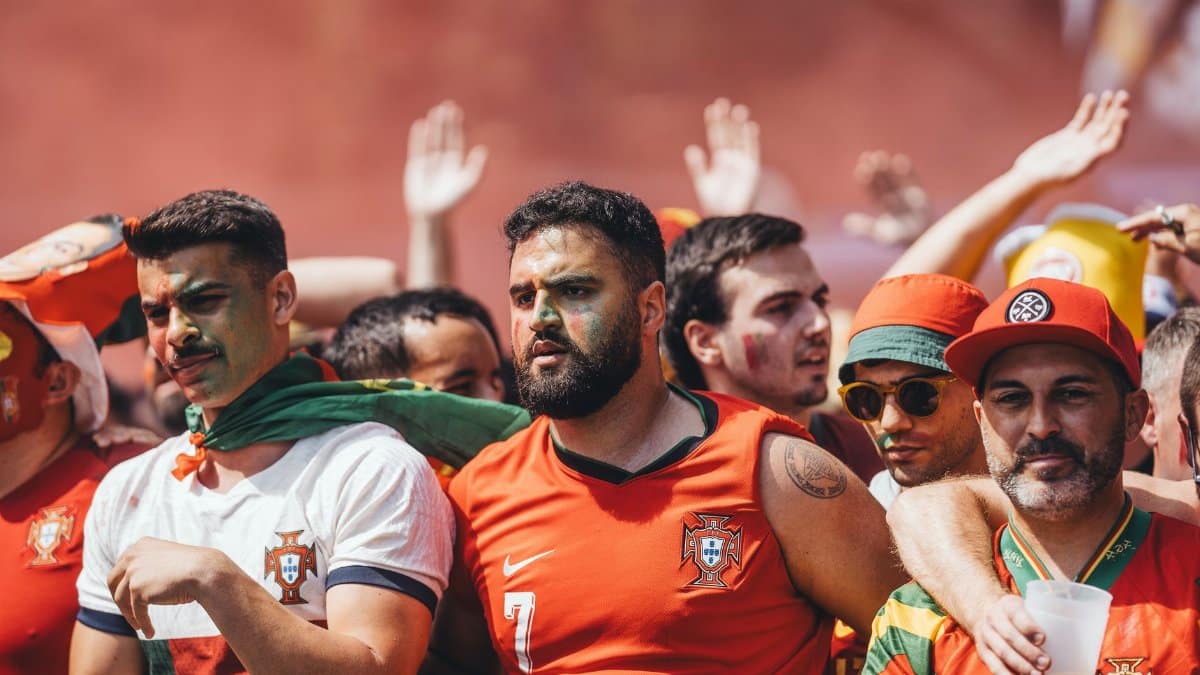 Group of passionate soccer fans cheering during a match, showcasing team spirit and celebration.