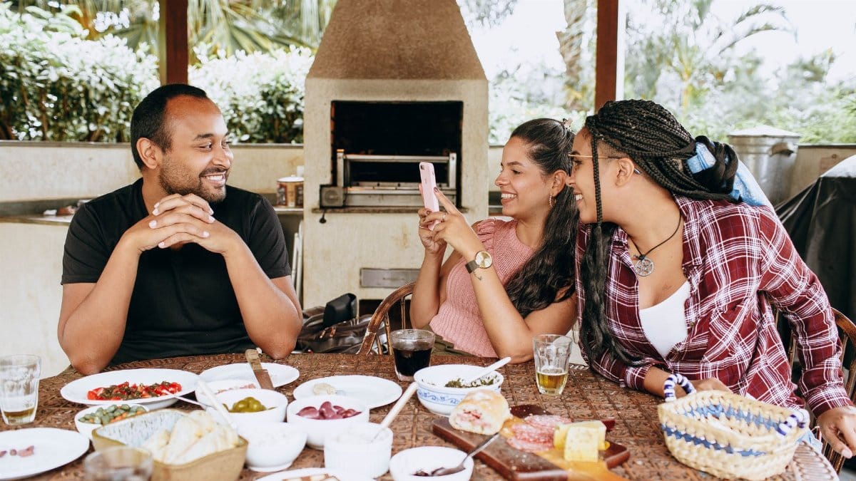 Friends enjoying a meal together outdoors, capturing a lively moment of conversation and connection.