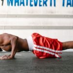 Athletic man doing push-ups indoors with motivational text.