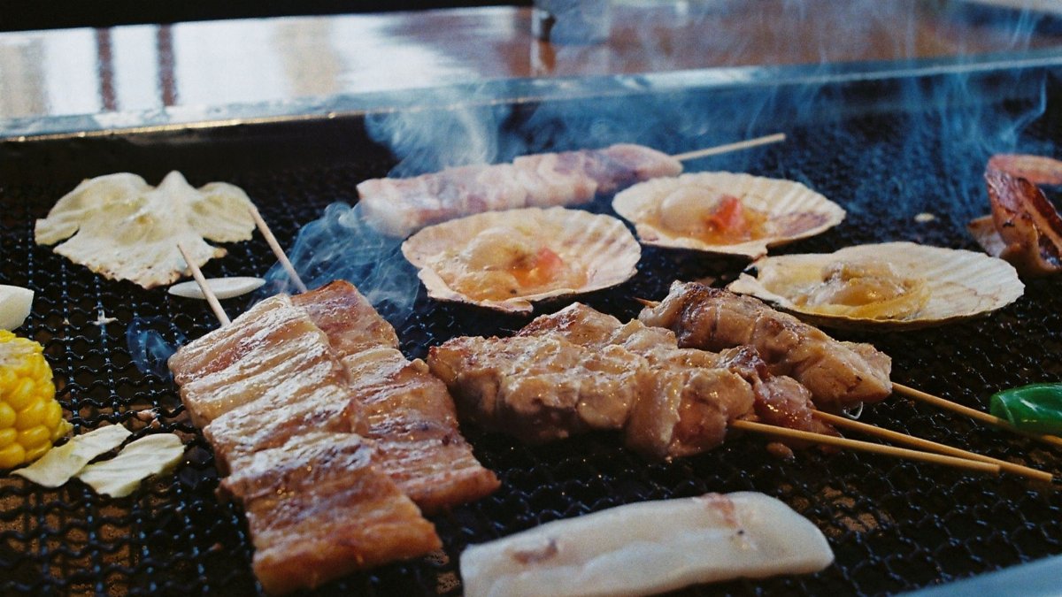 Grilled Japanese skewers and seafood sizzling on an open barbecue in Nagano, Japan.