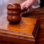 Close-up of a wooden judge's gavel on a desk in a courtroom, symbolizing justice.