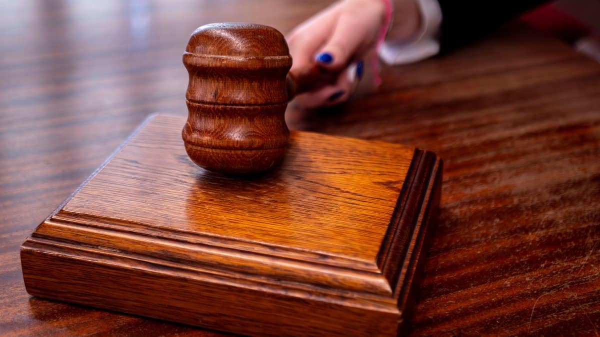 Close-up of a wooden judge's gavel on a desk in a courtroom, symbolizing justice.