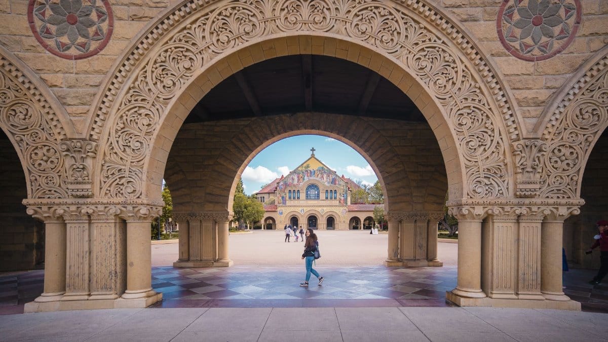 Intricate stone arches at Stanford University framing the scenic campus view.