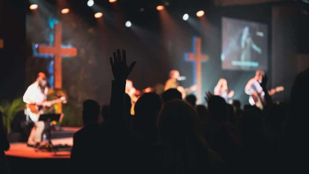 A vibrant church music band performing on stage with guitars and singers.